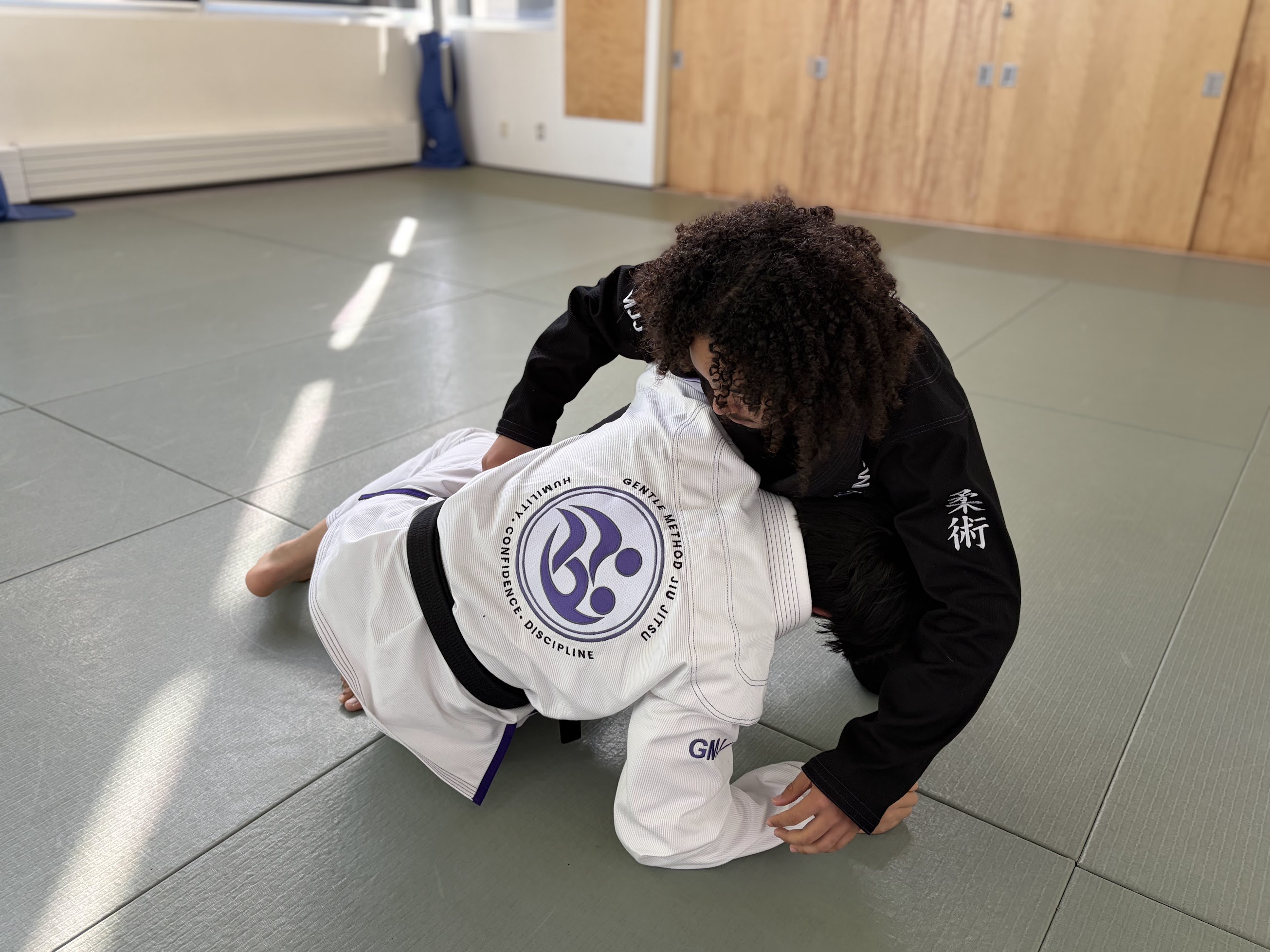 Students drilling a takedown on the mat